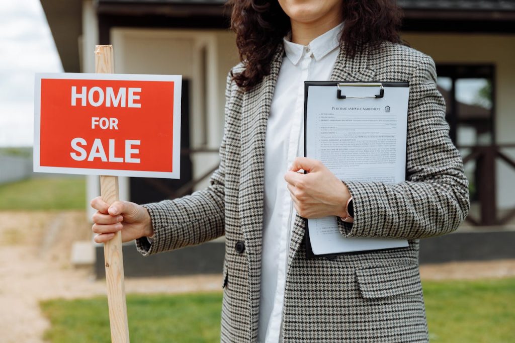 Realtor holding "for sale" sign to attract potential buyers.