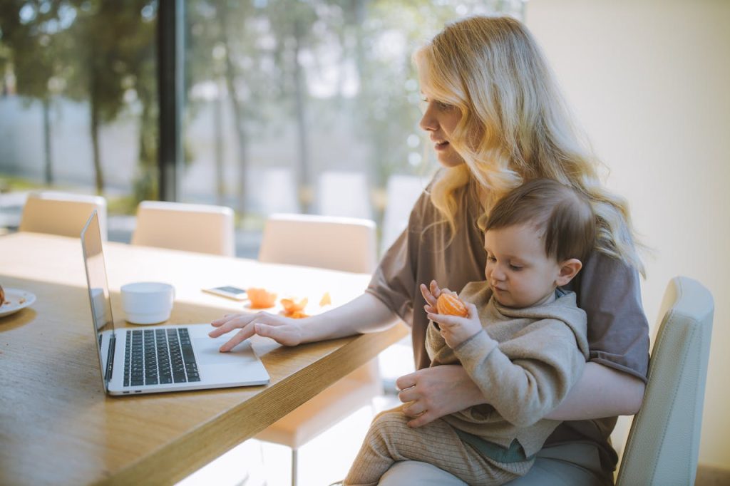 Woman searching for homes online with her kid