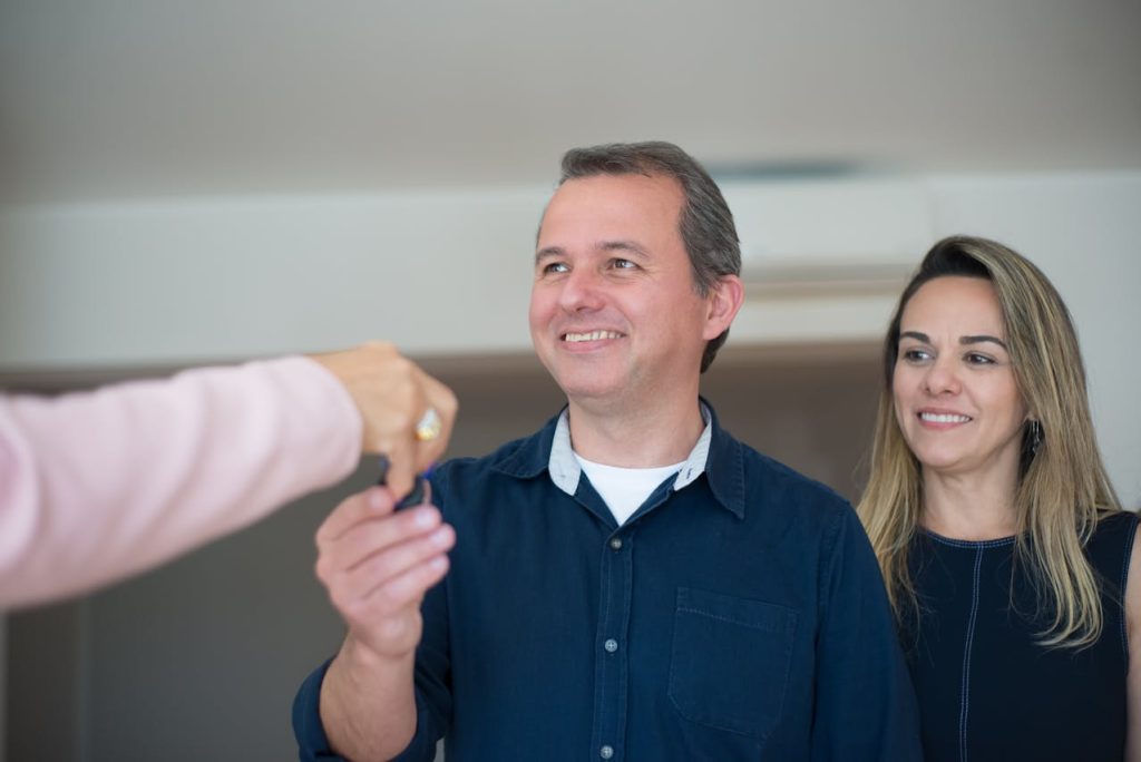 Real estate agent handing over the property keys to the new home owners