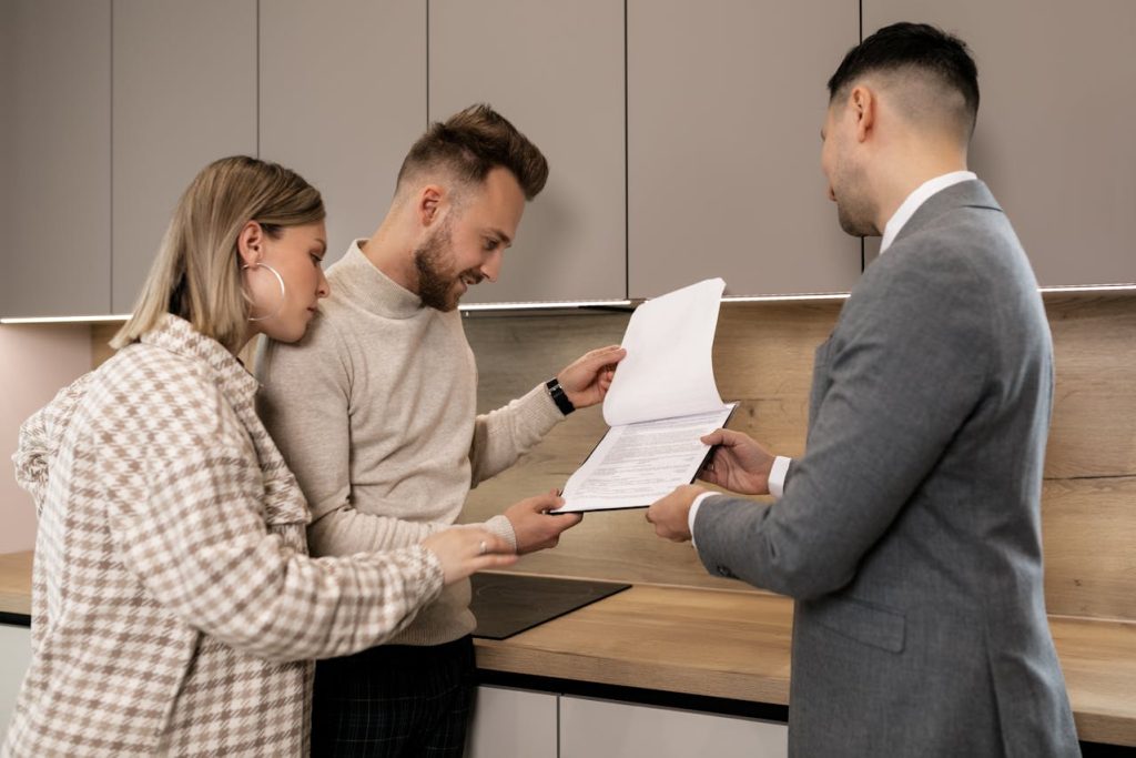 Real Estate Agent showing a property listing to his clients