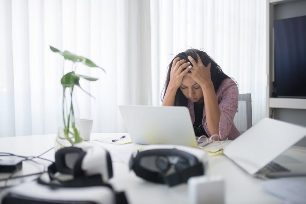 Real estate agent sitting in front of a laptop struggling with leads